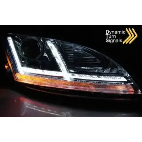 Headlights Audi TT 10-14 8J chrome LED med dynamiske blinklys, sett fra skrå vinkel mot mørk bakgrunn.