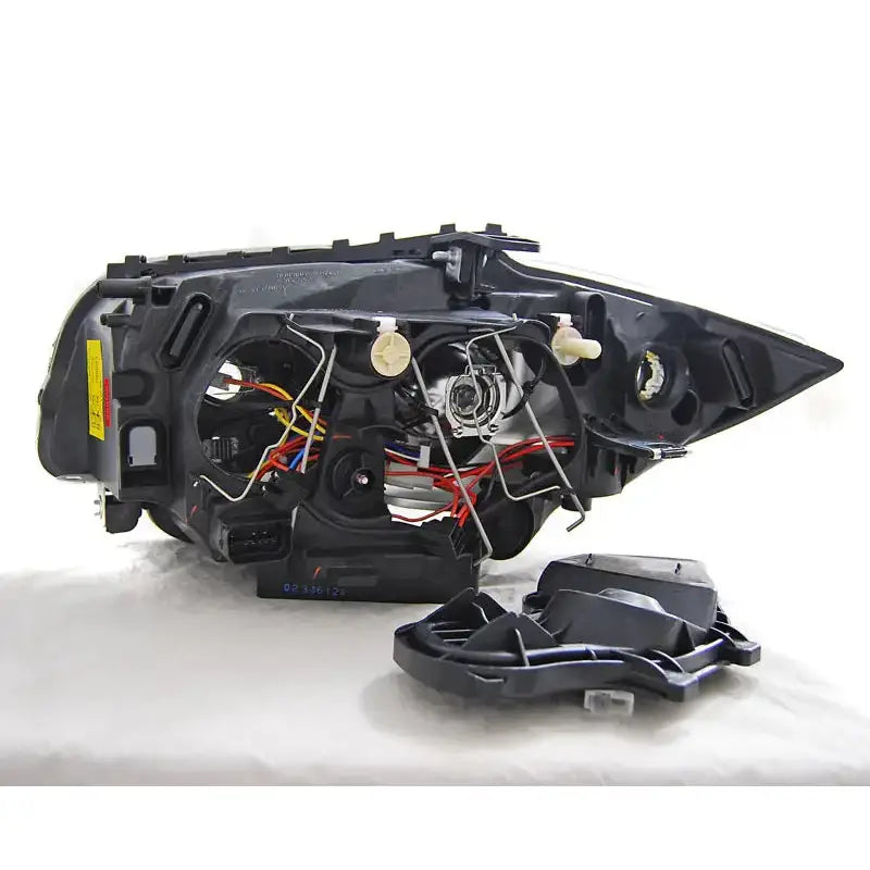 Hovedlys Bmw 1 E87/E81/82/88 04-11 sett bakfra med synlige ledninger og grå plastdeksel.