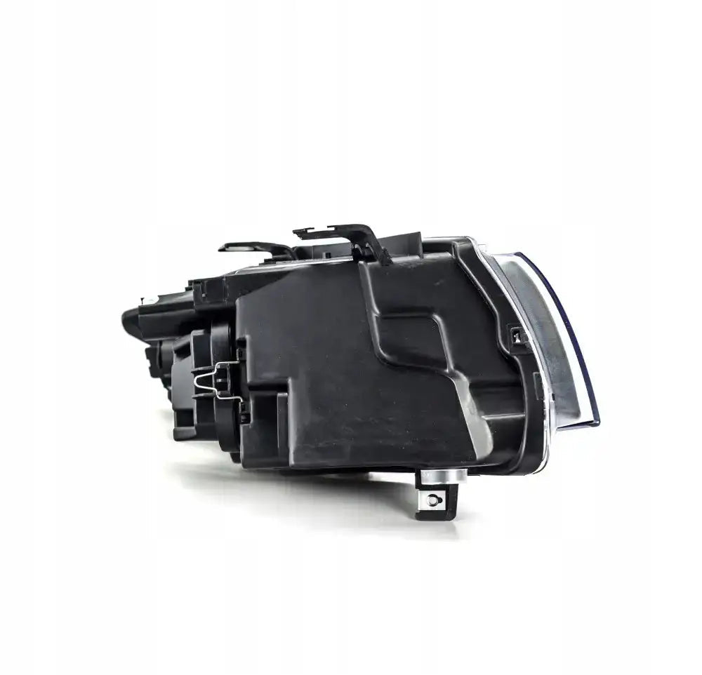 Hovedlys Bmw 3 Serie E90 E91 05-08 sett fra siden med klare linser og metallfester.