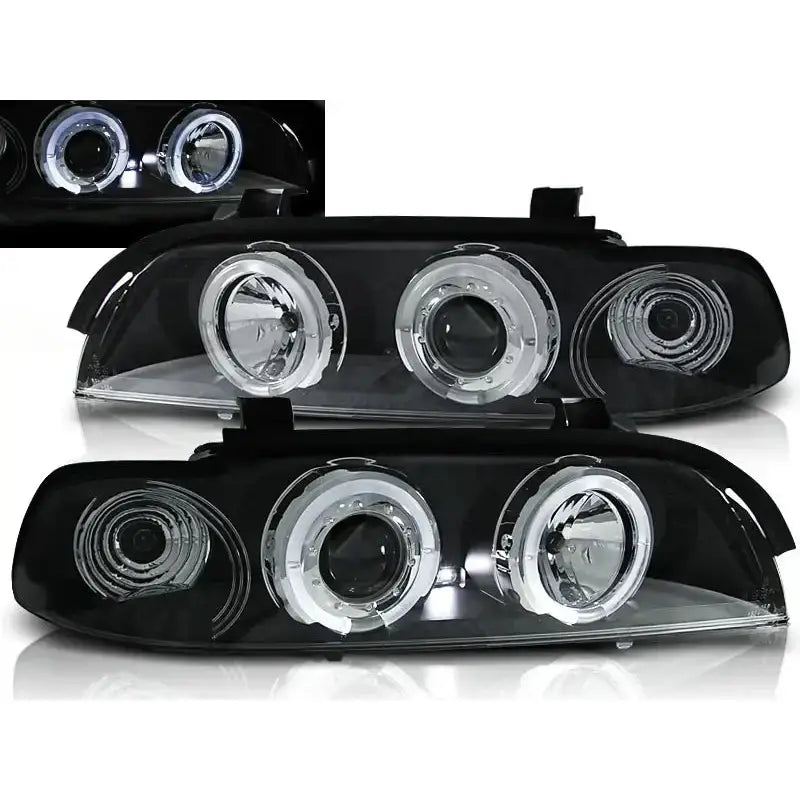 Frontlykter Bmw E39 Angel Eyes Black Clear med doble runde linser og klare detaljer, tent fra skrå vinkel.