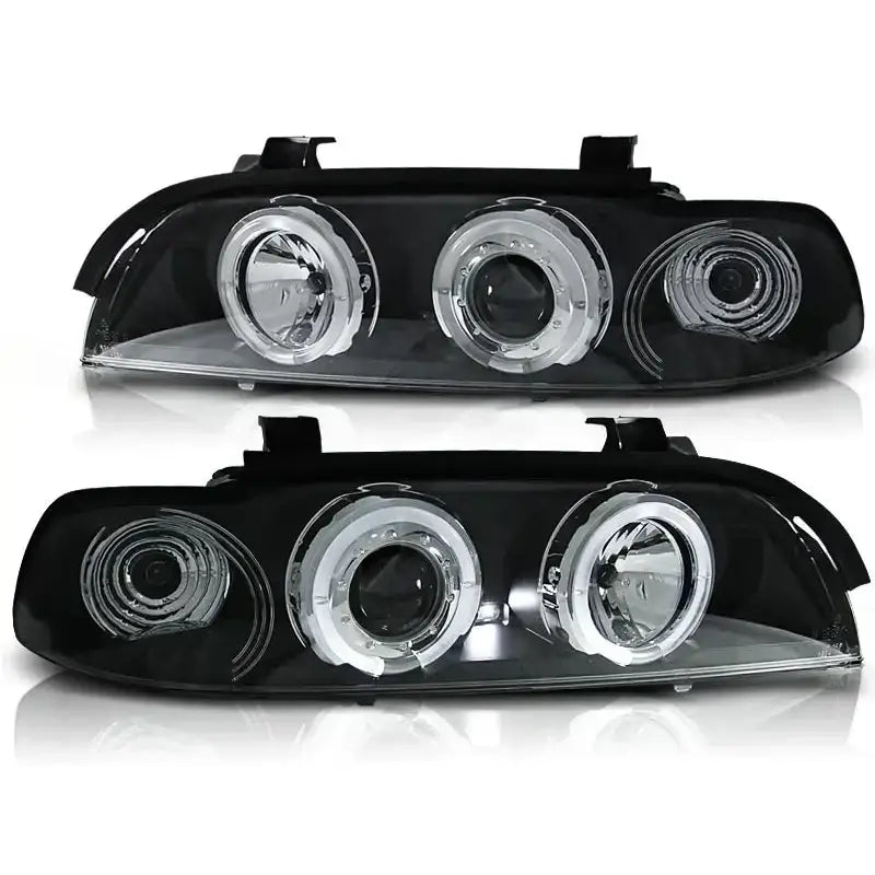 Hovedlykter Bmw E39 Angel Eyes Black Clear med tre runde linser, sett forfra mot hvit bakgrunn.
