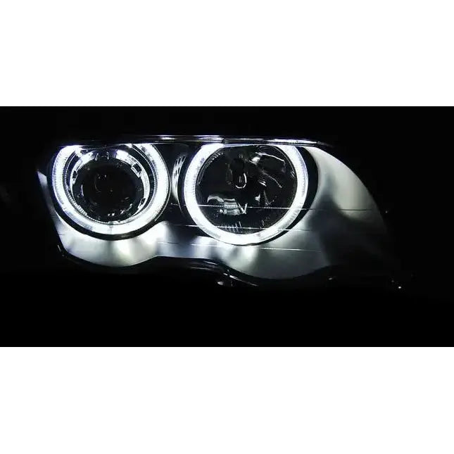 Hovedlys BMW E46 LED angel eyes i sort, nærbilde med runde lyssirkler sett forfra i mørkt miljø.