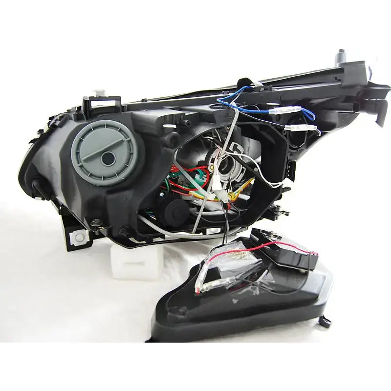 Hovedlys bakside av Bmw E60/E61 03-04 dual black med ledninger og elektronikk mot hvit bakgrunn.