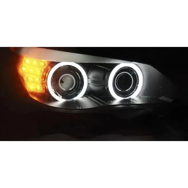 Headlamp Bmw E60/E61 Angel Eyes Black Led med hvite LED-ringer og oransje blinklys, nærbilde fra skrå vinkel.