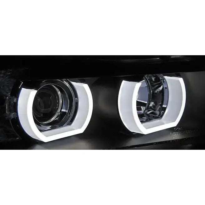 Headlights Bmw E90/E91 3D U-Type Black HID med hvite sekskantede LED-rammer, sett forfra i mørkt miljø.