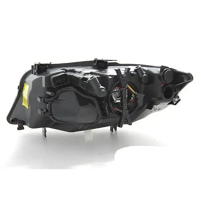 Frontlykter Bmw E90/E91 03.05-11 vist bakfra med ledningsnett, kontakter og detaljer mot hvit bakgrunn.