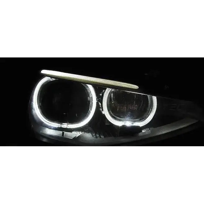 Hovedlys Bmw F20/21 11-12.14 AE True DRL Black med to LED-lysringer og lyslist mot svart bakgrunn.