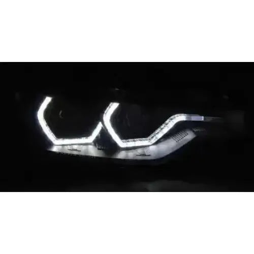 Hovedlykter Bmw F30/F31 Angel Eyes LED vist fra skrå vinkel med tydelige lysrammer i mørket.