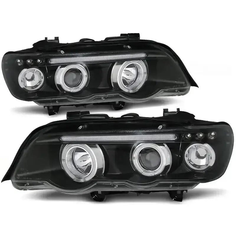 Frontlykter Bmw X5 E53 Angel Eyes Black med klart glass og LED-stripe, vist fra skrå vinkel.