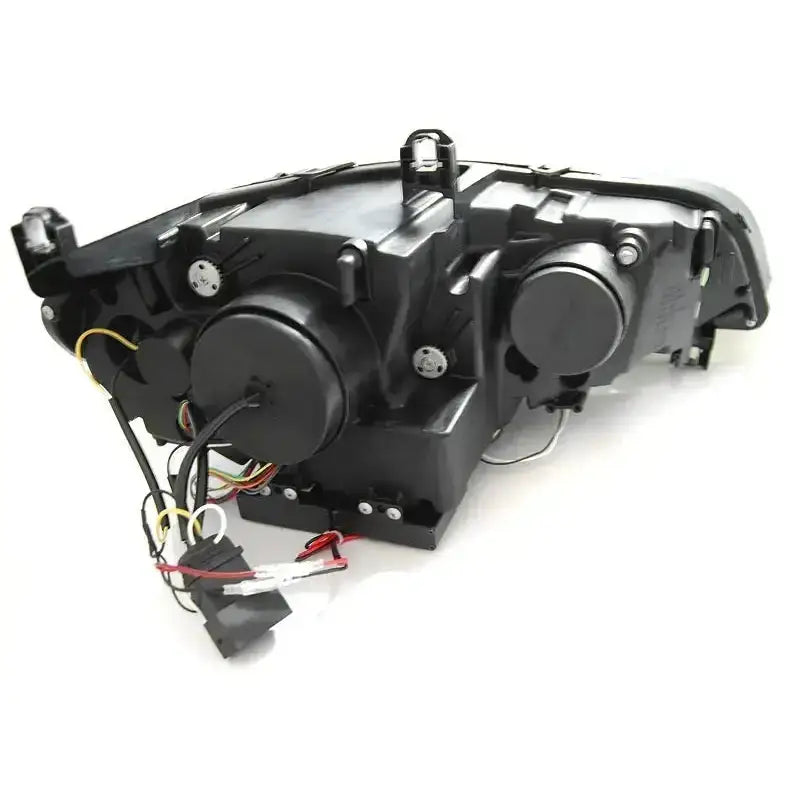 Headlamp bakside av Bmw X5 E70 frontlykt med ledninger, koblinger og to runde lokk synlige.