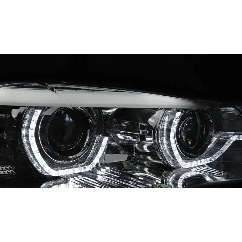 Headlights BMW X5 E70 LED billykter med hvite lyssirkler og klare linser, skrå vinkel.