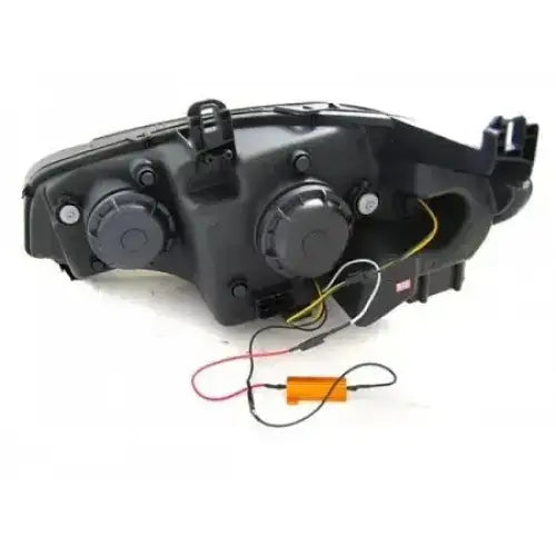 Headlights Bmw X5 E70 bakside med sorte deksler, ledninger, oransje motstand og synlige koblinger.