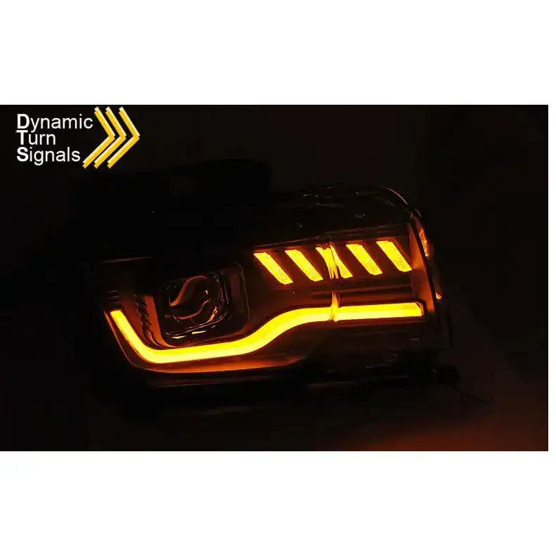 Hovedlykter Chevrolet Camaro 09-13 Tube Light Black med LED-striper og oransje blinklys i mørket.