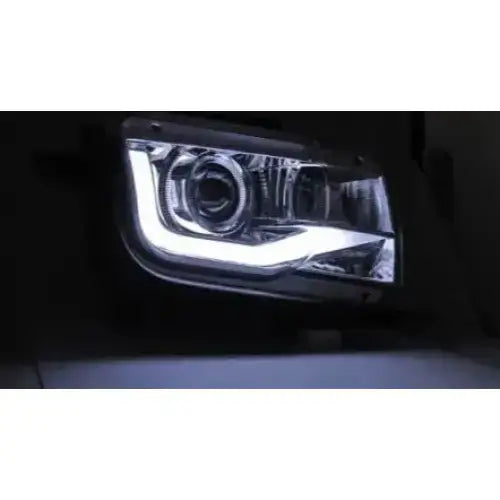 Hovedlykter Chevrolet CAMARO 09-13 Tube Light Chrome med LED-lys, skrått forfra i mørkt miljø.