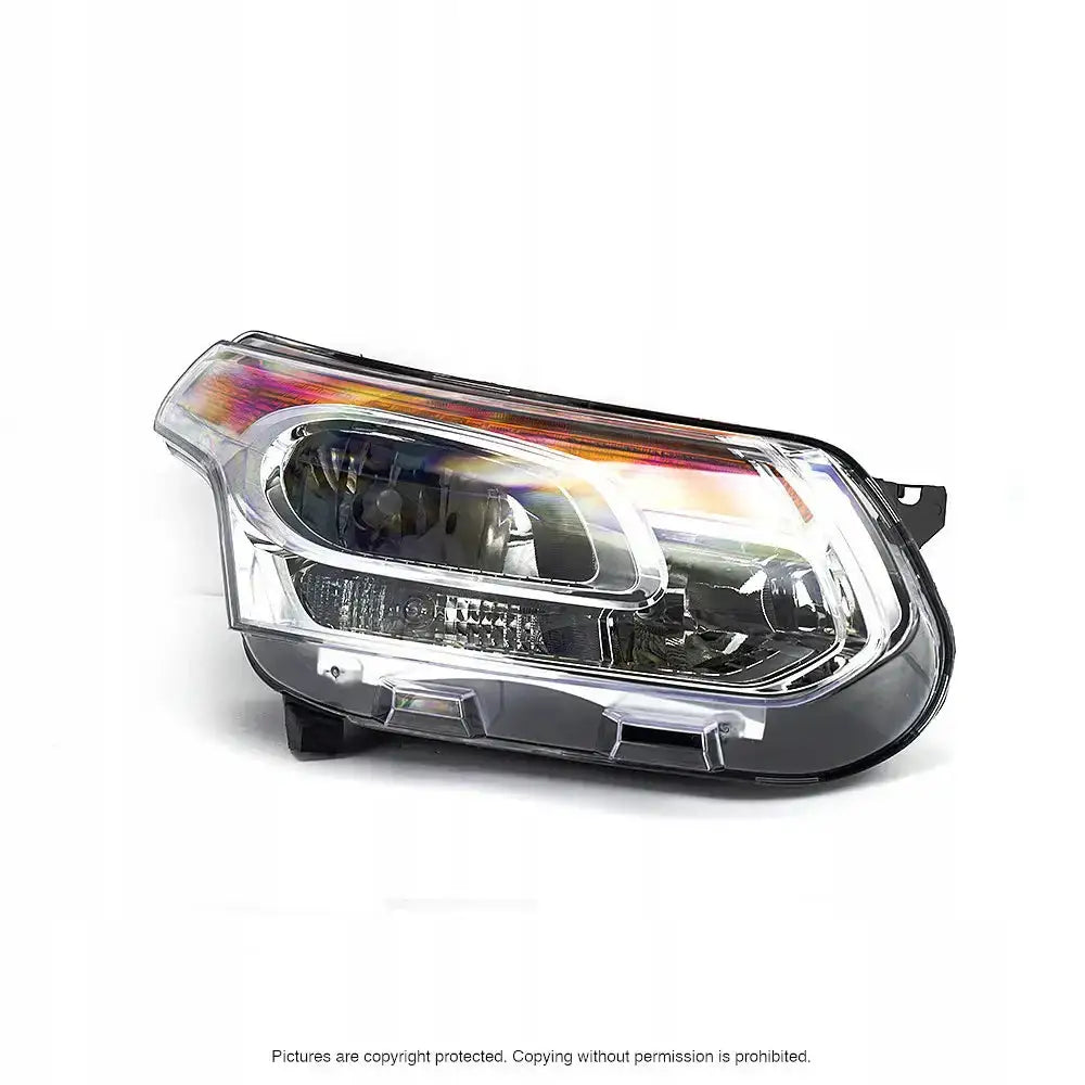 Hovedlykter Citroen C3 Picasso med sølvreflektorer og oransje detaljer, sett skrått forfra.