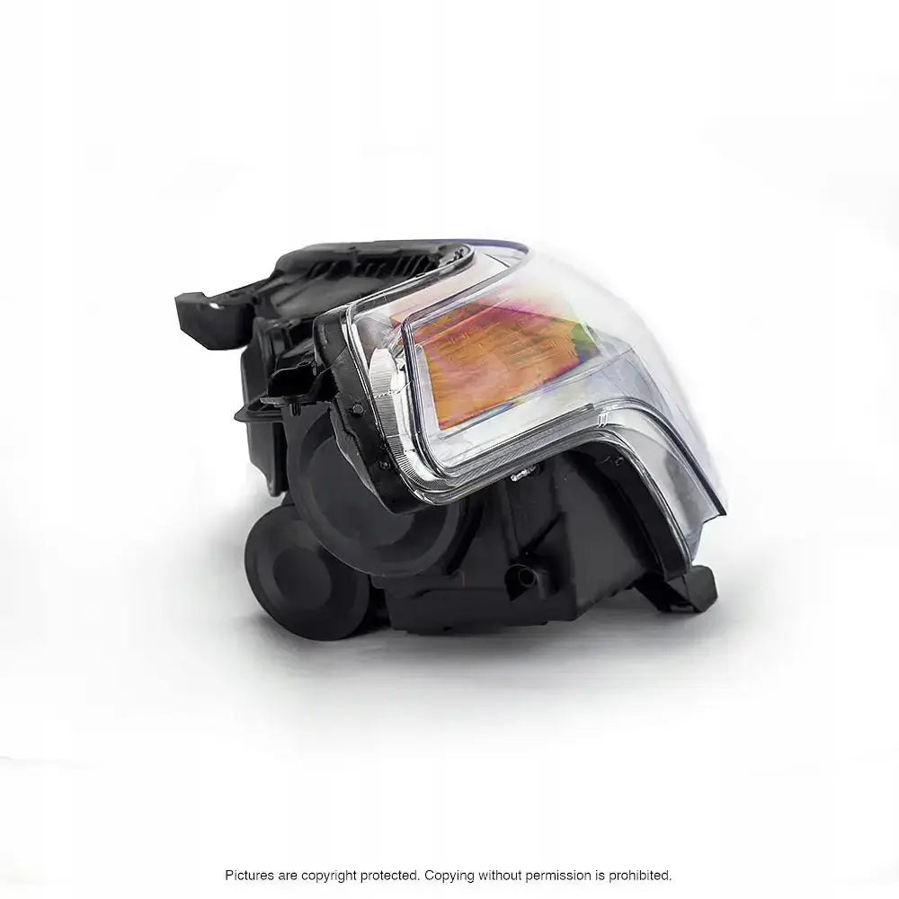 Headlights Citroen C3 Picasso med sort plast, klart glass og oransje reflektor sett fra skrå vinkel.