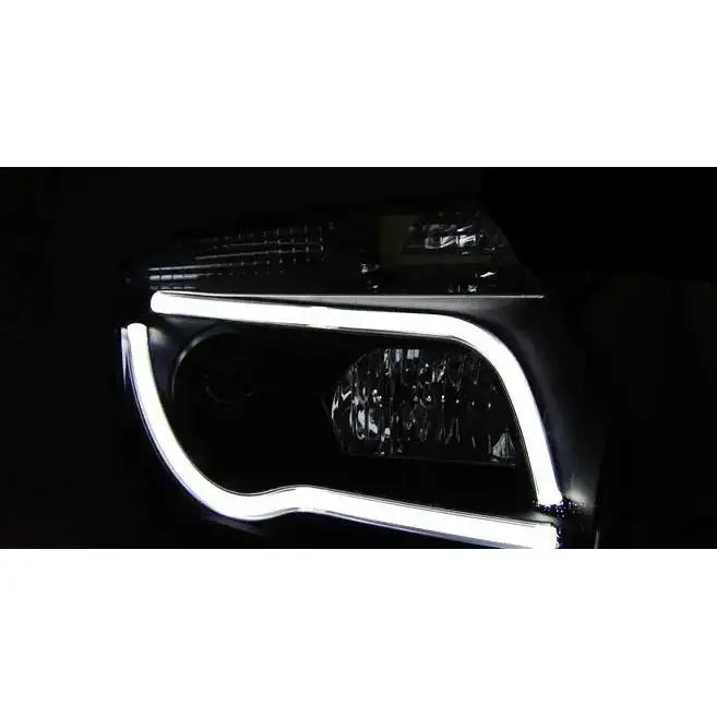 Hovedlys Dacia Duster 04.10-14 Black Tube Light med hvit LED-lysstripe i mørket.