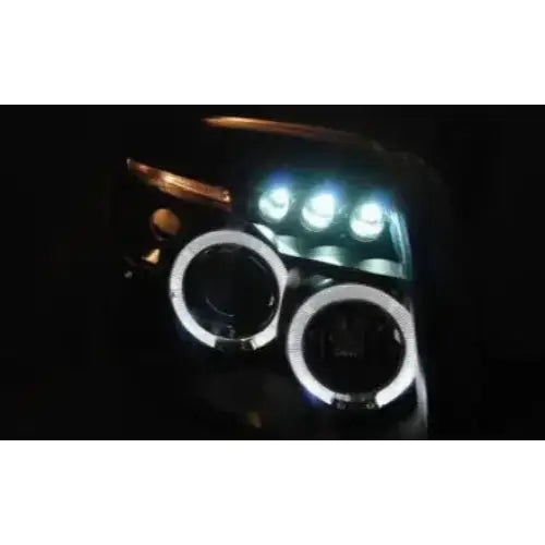 Hovedlykter Dodge CALIBER 06-12 Angel Eyes Black med LED og runde lyssirkler, sett forfra i mørket.