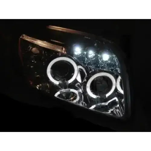 Hovedlykter Dodge Caliber Angel Eyes Chrome med tre LED-ringer og tre hvite LED-punkter, sett skrått.
