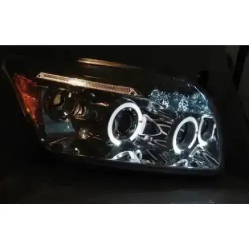 Hovedlys Dodge Caliber Angel Eyes Chrome med LED-lysringer og kromdetaljer, sett fra siden.