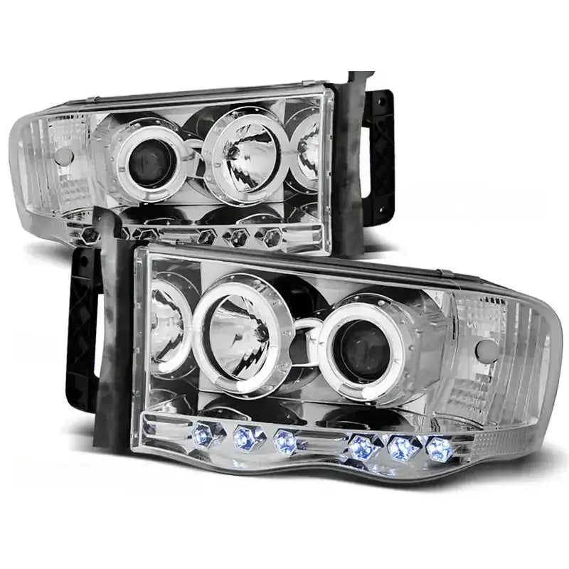 Frontlykter Dodge Ram 02-06 Angel Eyes Chrome med klare linser og blå LED-detaljer, sett skrått forfra.