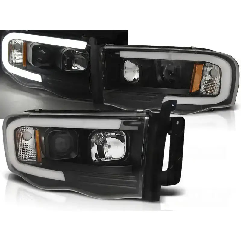 Frontlykter Dodge Ram 02-06 Tube Light Black med sort innfatning, hvit LED-list og oransje refleks.