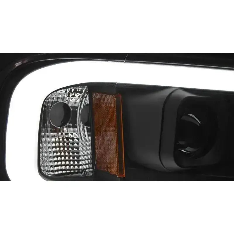 Headlights Dodge Ram 02-06 Tube Light Black med klare og oransje detaljer, nærbilde av lykteglass.