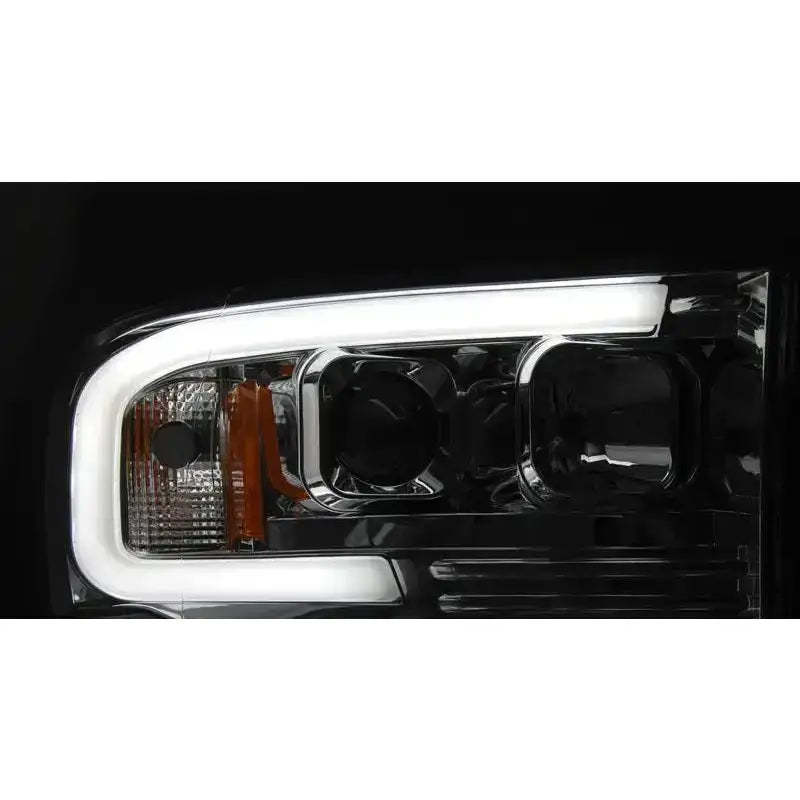 Hovedlykter Dodge Ram 02-06 Tube Light Chrome med LED-lys, kromdetaljer og oransje reflektor.