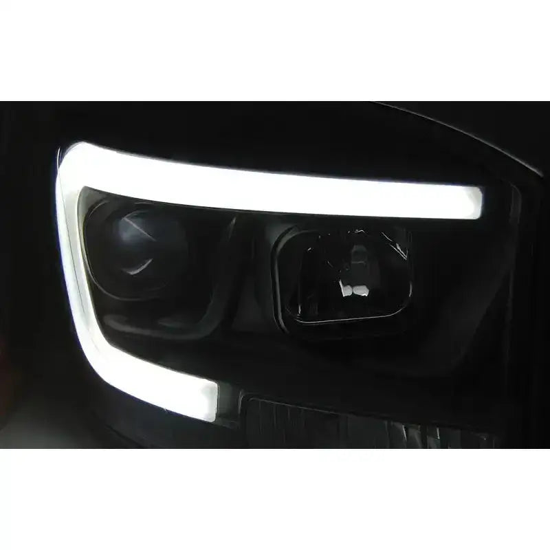 Hovedlys Dodge Ram 06-08 Tube Light Black med hvit LED-lyslinje og detaljer i glass og reflektor.