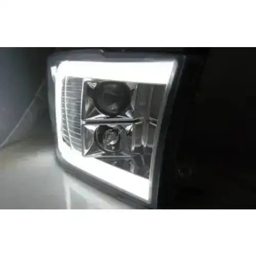 Hovedlykter Dodge Ram 09-18 Tube Light Chrome med hvit LED-ramme, sett fra skrå forside.