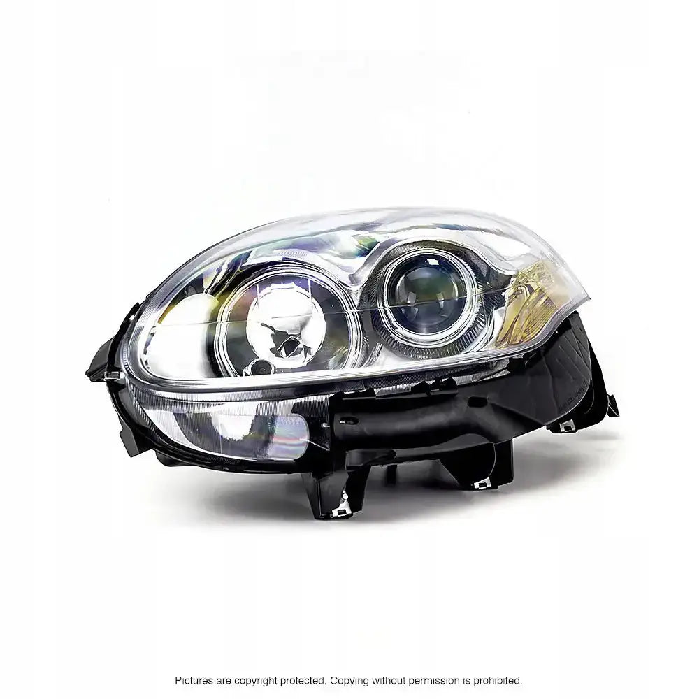 Hovedlykter Fiat Bravo II 06-14 med to reflektorer, klar plast og sort innfatning, sett fra skrå forside.