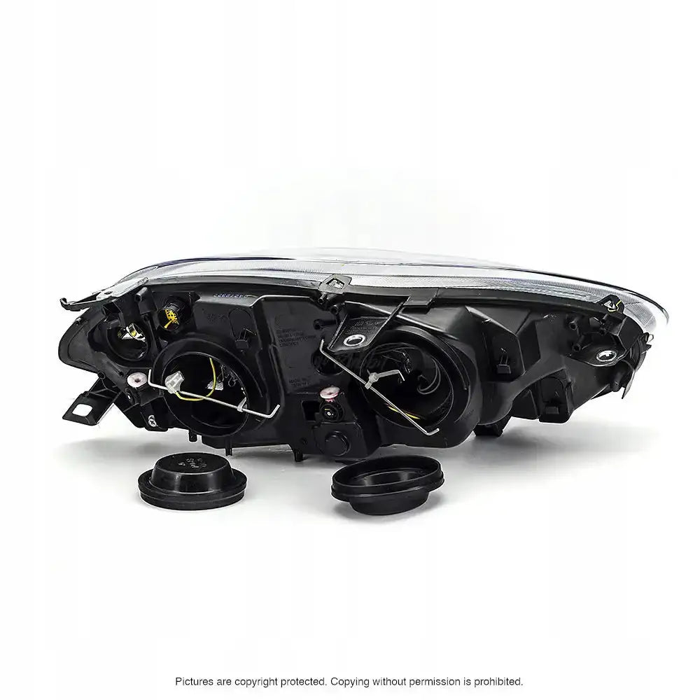 Headlamp bakside av Fiat Bravo II frontlykt med åpne deksler, synlige ledninger og festemekanismer.