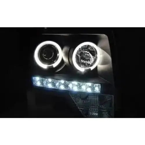 Hovedlykter Ford F150 Mk12 08-14 Angel Eyes Black med LED-lysringer og rad av LED-pærer vist i mørket.