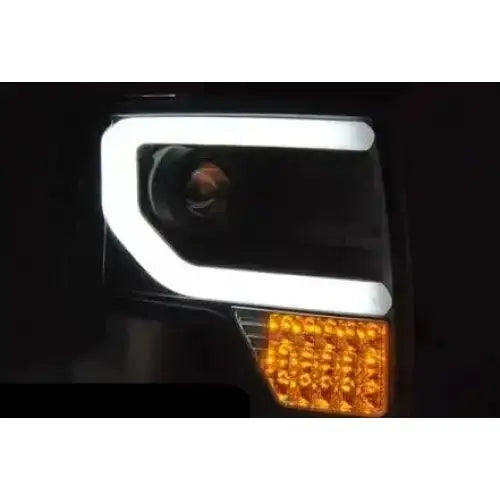 Hovedlykter Ford F150 Mk12 08-14 med hvit LED-ramme og oransje blinklys mot svart bakgrunn.