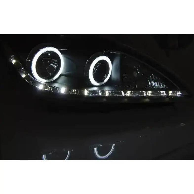 Headlights Ford Focus II Angel Eyes CCFL Black med LED-lysringer og hvite lysdioder i mørket.