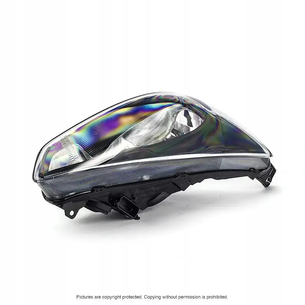 Frontlykter Ford Focus Mk3 med regnbuefargede refleksjoner i klart glass, sett skrått forfra.