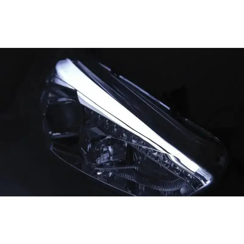 Hovedlys Ford Focus Mk3 15 med klart glass og hvit LED-lyslinje, sett fra skrå vinkel.