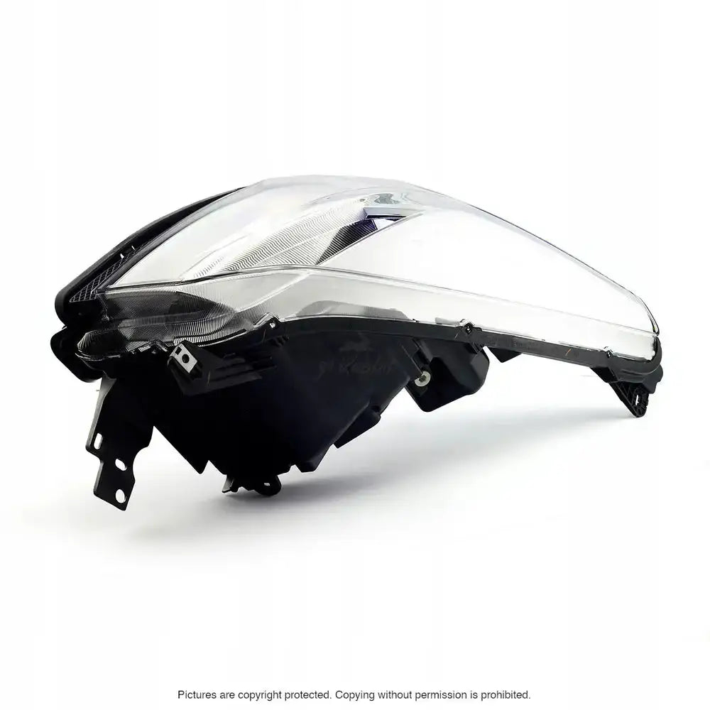 Hovedlykter Ford KUGA II 13-16 med klart glass og svart kant, sett fra siden med synlige reflektordetaljer.