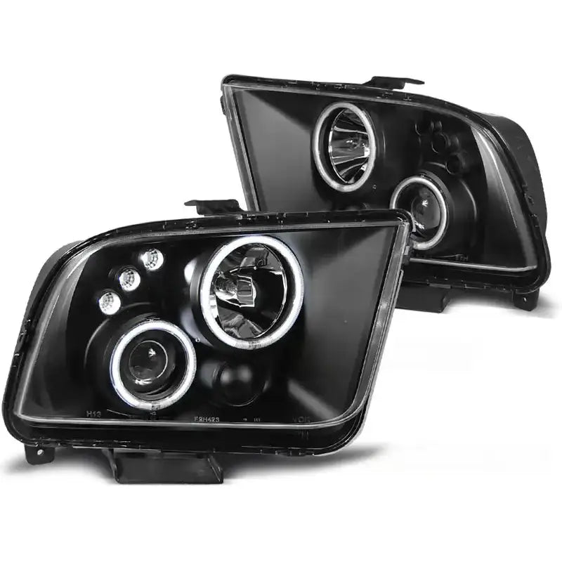 Hovedlykter Ford Mustang 04-09 Angel Eyes Black med to runde hovedlys og LED-lys, sett fra skrå vinkel.