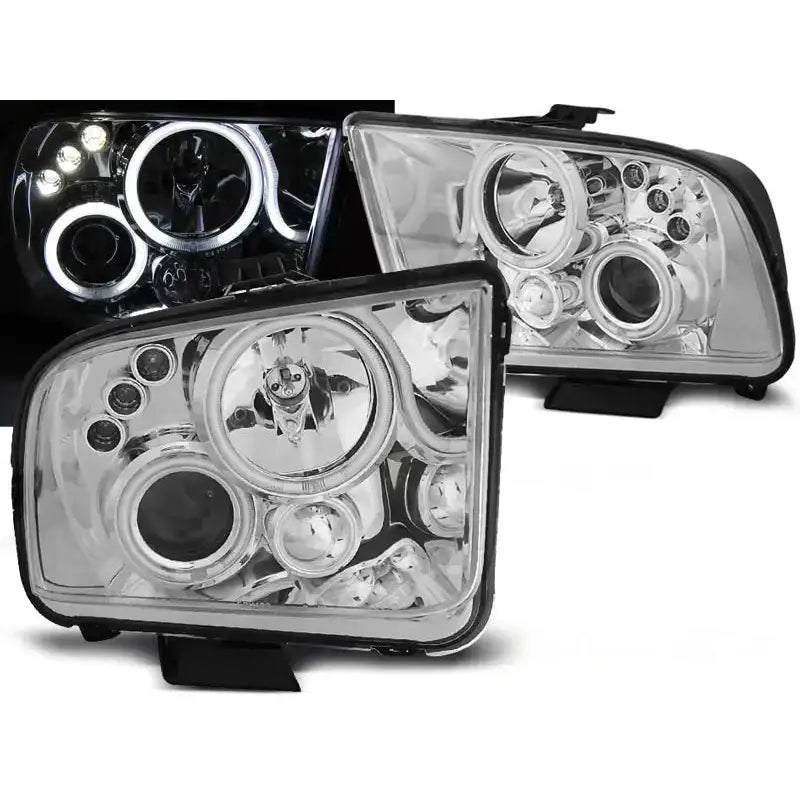 Frontlykter Ford Mustang 04-09 Angel Eyes Chrome med klar linse og blå LED-lys rundt lykteringene.
