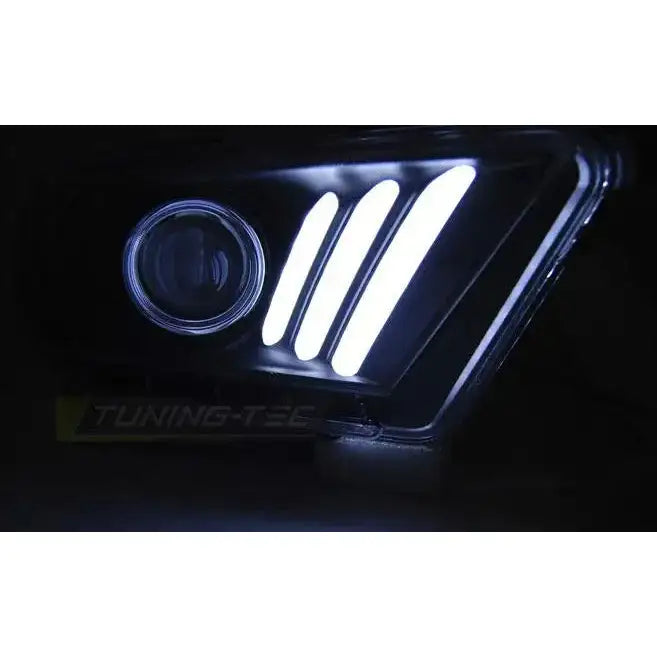 Hovedlys Ford Mustang V 10-13 med tre hvite LED-striper og rund projektorlinse på sort bakgrunn.