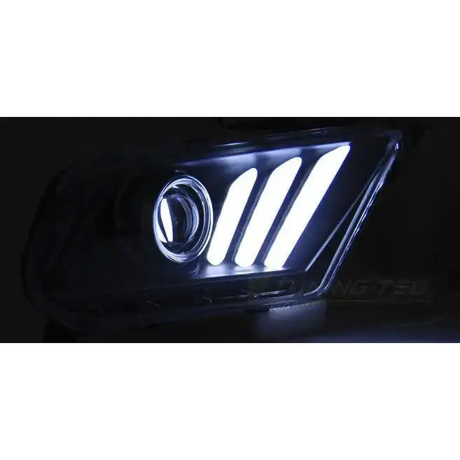 Headlights Ford Mustang V 10-13 med tre hvite LED-lysstriper og rund linse sett forfra i mørket.