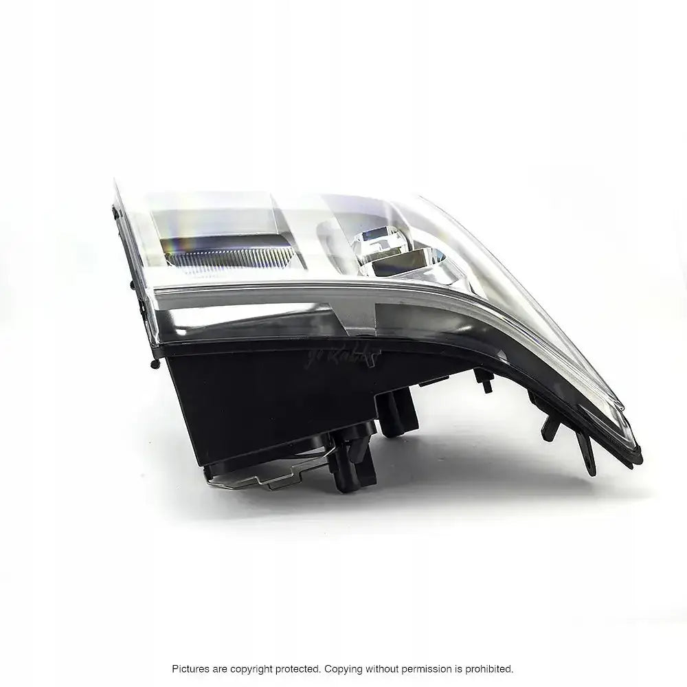 Frontlykter Ford Transit 06-13 H4 med klart deksel og sorte detaljer sett fra skrå vinkel.