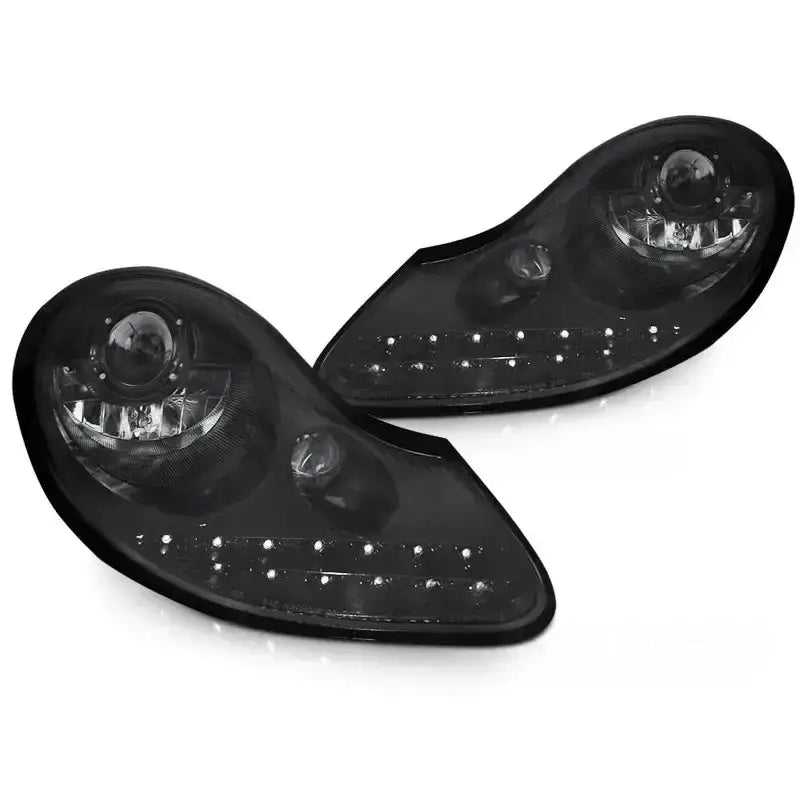 Frontlykter Glossy Black Porsche Boxster 96-04 med LED-lys, sett fra skrå vinkel mot hvit bakgrunn.