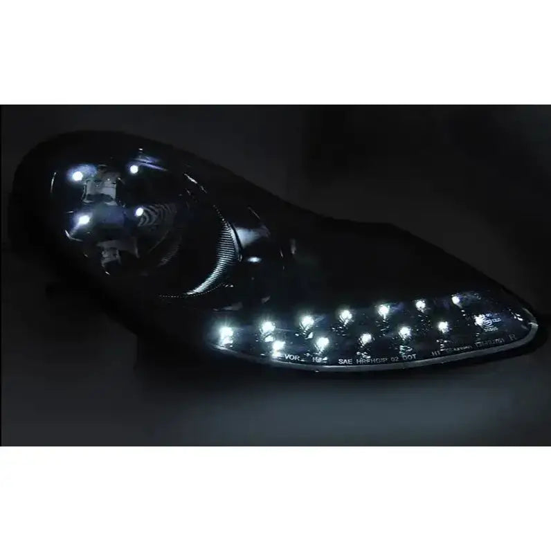 Hovedlys Glossy Black Porsche Boxster 96-04 med sterke LED-lys sett forfra i mørket.