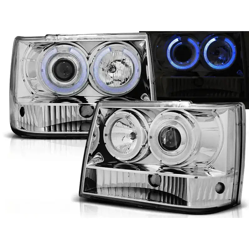 Frontlykter Grand Cherokee 93-98 i krom med to runde linser og LED-lysringer, frontvisning.