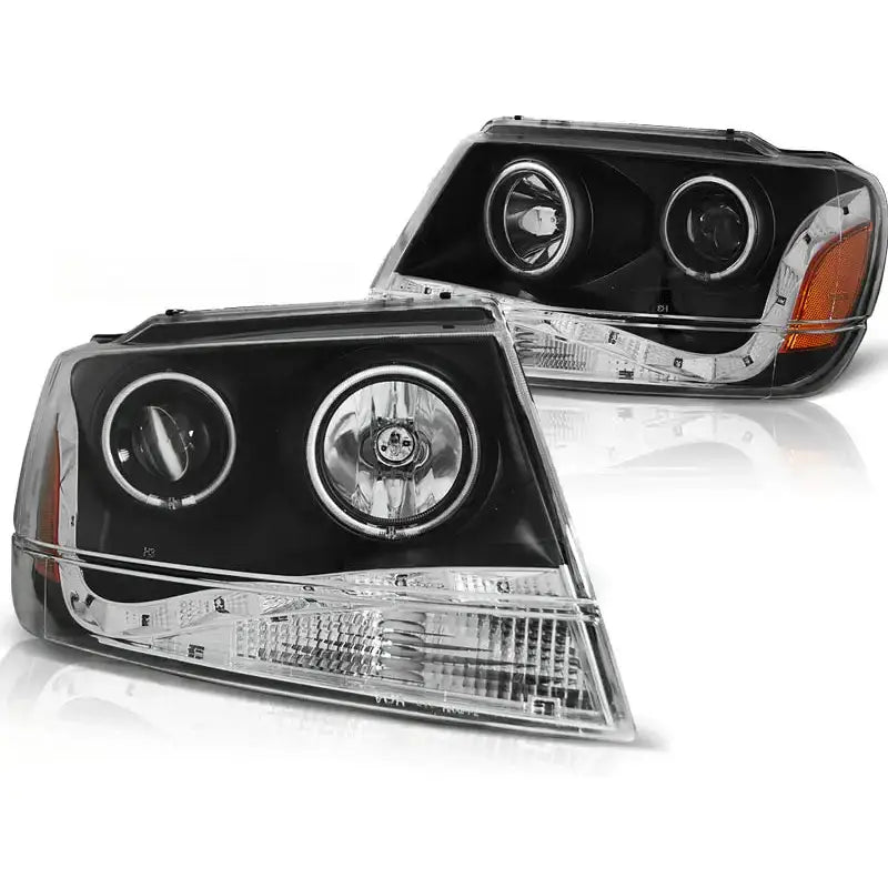Hovedlykter Grand Cherokee 99-05.05 Daylight Black med sorte detaljer og to runde lykter, sett skrått.
