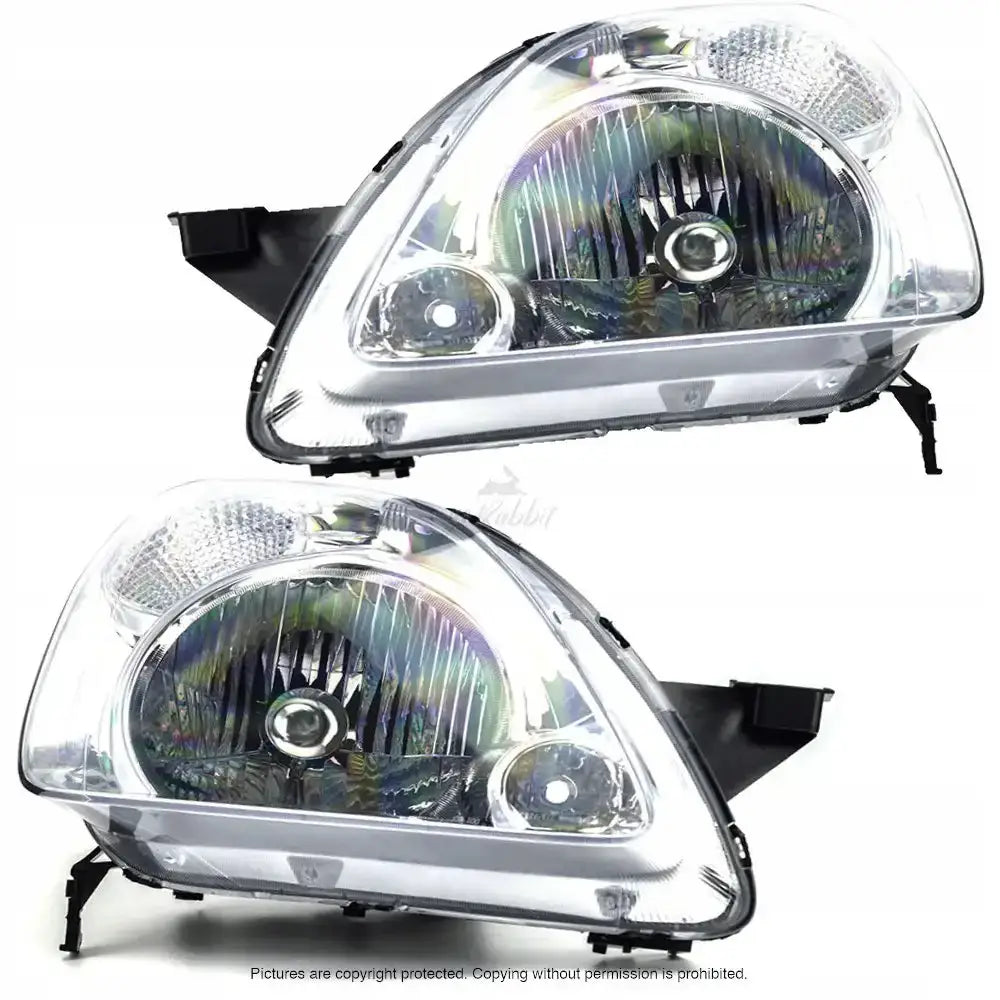 Frontlykter Honda CRV 01-04 i klar plast med sølvfargede reflektorer, sett fra skrå forside.