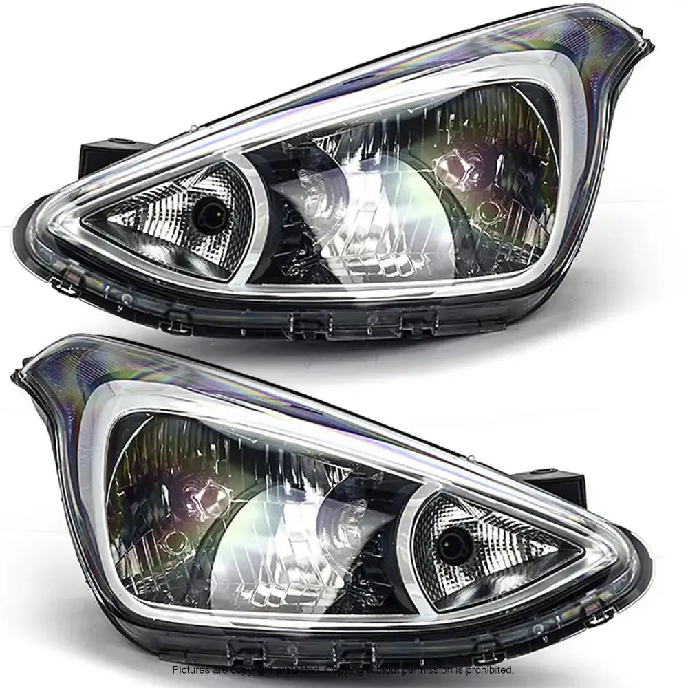 Frontlykter Hyundai i10 13-16 H4 sett med klart glass og svart plast, vist skrått forfra.