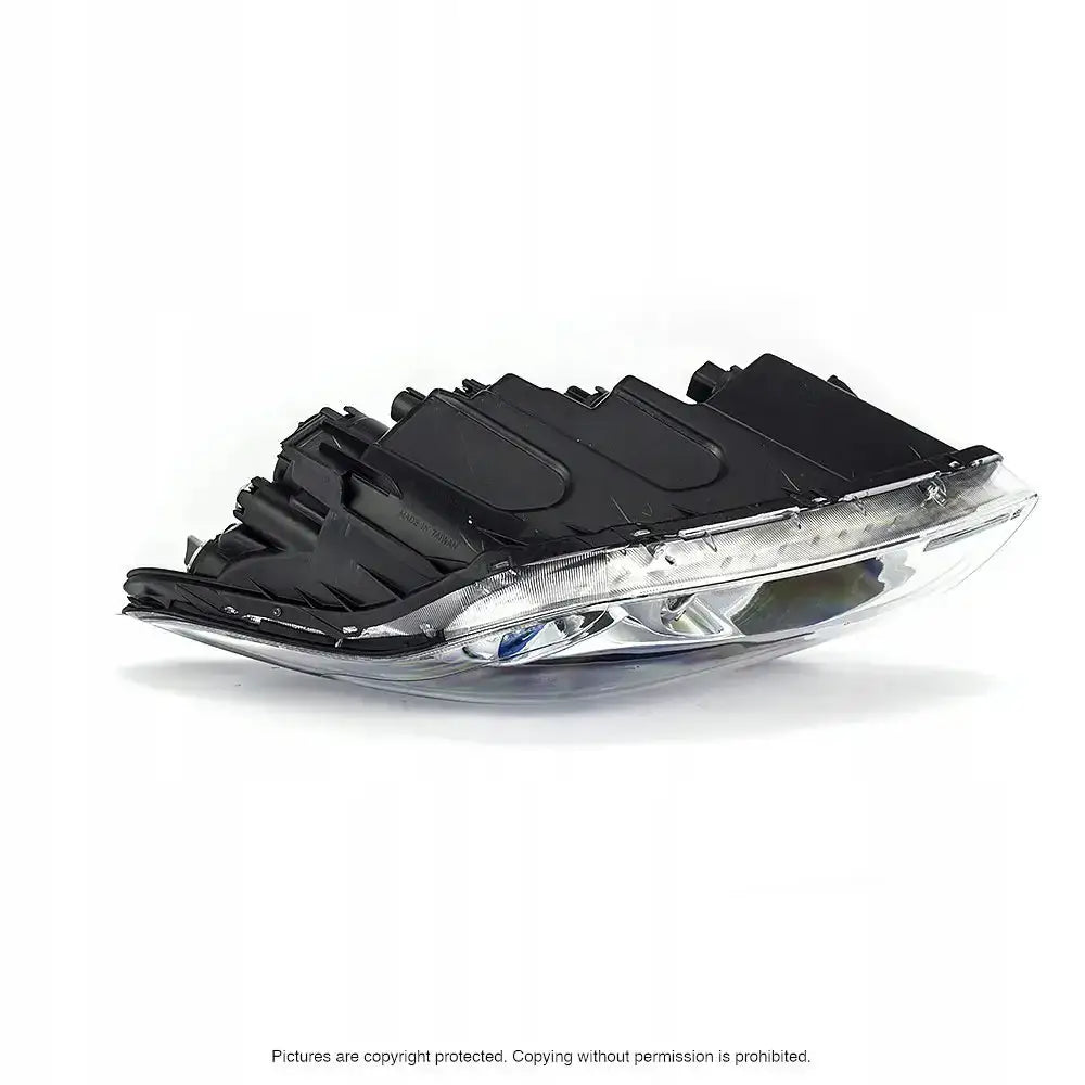 Hovedlykter Hyundai i30 07-10 vist fra skrå vinkel med sølv og svart plastdetaljer mot hvit bakgrunn.